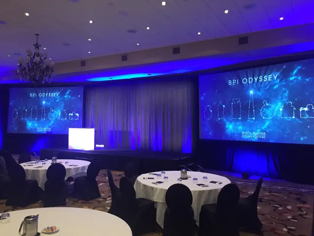 Corporate gala ballroom with blue uplighting and twin projection screens